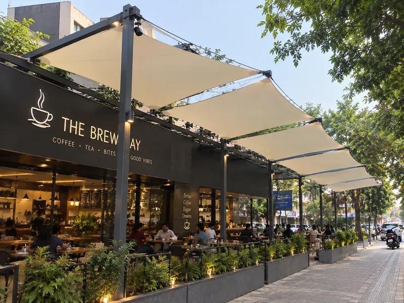 Tensile pergola with cantilevered fabric panels over a cafe terrace